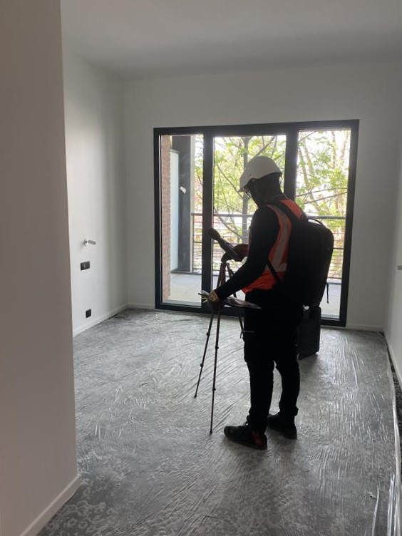 Acousticien équipé d'une source sonore dodécaédrique réalisant une mesure d'isolement acoustique dans un logement neuf en cours de finition